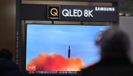 A man walks past a television showing a news broadcast with file footage of a North Korean missile test, at a railway station in Seoul on March 9, 2023. - North Korea fired a short-range ballistic missile on March 9, Seoul's military said, Pyongyang's latest show of force just days before South Korea and the United States kick off major joint military exercises. (Photo by Anthony WALLACE / AFP)