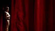 A decorative Oscar statue stands near red drapes as final preparations are made for the 95th Academy Awards, in Hollywood, Los Angeles, California, on March 11, 2023. (Photo by Stefani Reynolds / AFP)