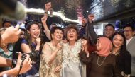 Janet Yeoh (centre R), mother of actress Michelle Yeoh, celebrates after her daughter won the award for Best Actress in a Leading Role at the 95th Academy Awards in Los Angeles, at an event in Kuala Lumpur on March 13, 2023. (Photo by Arif Kartono / AFP)