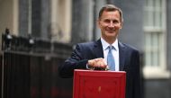 Britain's Chancellor of the Exchequer Jeremy Hunt poses with the red Budget Box as he leaves 11 Downing Street in central London on March 15, 2023, to present the government's annual budget to Parliament. (Photo by JUSTIN TALLIS / AFP)