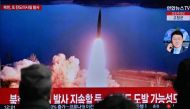 People watch a television showing a news broadcast with file footage of a North Korean missile test, at a railway station in Seoul on March 19, 2023. (Photo by Anthony Wallace / AFP)
 