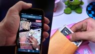 This illustration picture shows the “cash stuffing” TikTok trend, videos where people put cash in envelopes as a budgeting method, displayed on a smartphone in Washington, DC, on March 15, 2023. Photo by OLIVIER DOULIERY / AFP