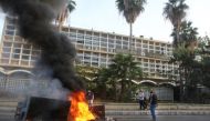 File Photo: Lebanese demonstrators block a road with burning tyres in front of the Electricite Du Liban company building in the southern city of Sidon, as the country struggles with a deep economic crisis. (AFP)