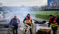 Unionists blockade the entrance to the E. Leclerc retail store dispatch center as protests continue across France after the French government pushed a pensions reform through parliament without a vote, using the article 49.3 of the constitution, in Saint-Etienne-de-Montluc, on March 24, 2023. (Photo by LOIC VENANCE / AFP)