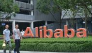 This file photo taken on May 27, 2022 shows staff members walking past the logo of Chinese e-commerce giant Alibaba at its headquarters in Hangzhou, in China's eastern Zhejiang province. Photo by AFP