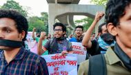 University students hold placards and shout slogans during a protest demanding the immediate release of journalist Shamsuzzaman Shams, who has been charged under the Digital Security Act, at Dhaka University campus in Dhaka March 29, 2023. (Photo by AFP)