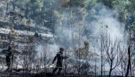 Fire fighters douse off a forest area burnt by a wildfire that began on March 23, in Fuente de la Reina, near Castellon, on March 29, 2023. Photo by Jose Jordan / AFP