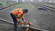 A railroad worker repairs damaged tracks after a strike in the town of Druzhkivka, Donetsk region on March 30, 2023, amid the Russian invasion of Ukraine. (Photo by Genya Savilov / AFP)