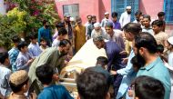 Mourners carry the coffin of a stampede victim for his funeral in Karachi on April 1, 2023. (Photo by Rizwan Tabassum / AFP)