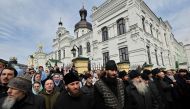 Believers of the Ukrainian Orthodox Church, accused of maintaining links with Moscow, pray outside the historic Kiev-Pechersk Lavra monastery in Kiev, on April 1, 2023. (Photo by Sergei CHUZAVKOV / AFP)
 