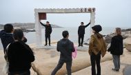 Chinese tourists pose for photos in front of the Taiwan Strait, on the coast of Pingtan island, the closest point to Taiwan, in China's southeast Fujian province on April 6, 2023. (Photo by Greg Baker / AFP)