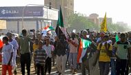 Sudanese protesters take part in a demonstration in southern Khartoum on April 6, 2023 marking a key anniversary in the decades-old struggle against military rule with new protests against the general. (Photo by Ebrahim Hamid / AFP)