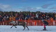 Spectators watch a reindeer and jockey compete in the finals of the PoroCup, a Finnish reindeer race on the frozen lake of Inari, Finland on April 9, 2023. (Photo by Alessandro Rampazzo / AFP)
