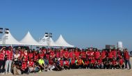 Volunteers of QRCS pose during Fuwairit Beach cleaning campaign.