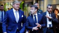 France's President Emmanuel Macron (C) and King Willem-Alexander of the Netherlands (L) walk during a visit of the experimental quantum physics laboratory of the University of Amsterdam before signing a 