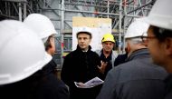 French President Emmanuel Macron, wearing a working helmet, talks with conservation experts as he visits the restoration site at the Notre-Dame de Paris Cathedral, which was damaged in a devastating fire four years ago, in Paris, France, April 14, 2023. (Photo by SARAH MEYSSONNIER / POOL / AFP)
