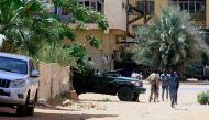 People walk past a military vehicle in Khartoum on April 15, 2023, amid reported clashes in the city  Photo by AFP