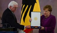 German President Frank-Walter Steinmeier (left) awards the Order of Merit to former German Chancellor Angela Merkel at the Bellevue presidential palace in Berlin on April 17, 2023. (Photo by John MacDougall / AFP)