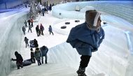 Visitors climb stairs in sub-zero temperatures at the Ice Magic: Fantasy On Ice indoor traveling event by Apollo Media, in Bangkok on April 19, 2023, amidst a heatwave across the region. Photo by Lillian SUWANRUMPHA / AFP