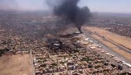 This image grab taken from AFPTV video footage on April 20, 2023, shows an aerial view of black smoke rising above the Khartoum International Airport amid ongoing battles between the forces of two rival generals. (Photo by AFP)