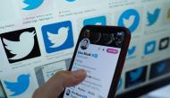This illustration photo taken in Los Angeles on April 20, 2023, shows Elon Musk's blue tick next to his name on a smartphone. (Photo by Chris Delmas / AFP)

