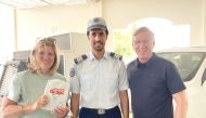 A Customs official poses with tourists at the Abu Samra border.