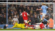 Manchester City's Norwegian striker Erling Haaland (R) scores the team's fourth goal during the English Premier League football match between Manchester City and Arsenal at the Etihad Stadium in Manchester, north west England, on April 26, 2023. (Photo by Oli SCARFF / AFP). 
