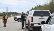 An Alberta Fish and Wildlife officer deters drivers at police roadblock outside the town of Drayton Valley, Alberta, Canada on May 7, 2023. Photo by Walter Tychnowicz / AFP