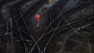 This file photo taken on August 12, 2021 shows a worker walking next to the rails at a transshipment point for freight trains in Hagen, western Germany, as Deutsche Bahn employees went on strike over wages. Photo by Ina FASSBENDER / AFP
