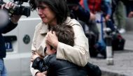 A parent escorts her child following a shooting at a school in the capital Belgrade on May 3, 2023. (Photo by Oliver Bunic / AFP)

