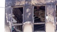 A burnt out window is seen at the Loafers Lodge hostel in the aftermath of a fire in the suburb of Newtown in Wellington on May 17, 2023. Photo by Marty MELVILLE / AFP