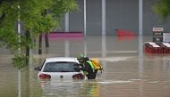 A speleological alpine rescuer looks in a car for missing persons near a supermarket in a flooded area in Cesena on May 17, 2023. Photos by Alessandro SERRANO / AFP