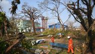 :Members of a rescue team clean up fallen trees in Sittwe on May 17, 2023, in the aftermath of Cyclone Mocha's landfall. (Photo by SAI Aung MAIN / AFP)
