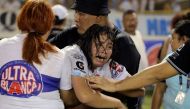 A woman is held by other as she cries following a stampede during a football match between Alianza and FAS at Cuscatlan stadium in San Salvador, on May 20, 2023. (Photo by Milton Flores / AFP)