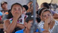 Relatives and friends of the victims of a fire on the eve that killed at least 19 youths and injured about 20 others in a schoolgirls' dormitory, cry during a meeting with Guyana's President Irfaan Ali, in Mahdia, Guyana. (Photo by Keno GEORGE / AFP)