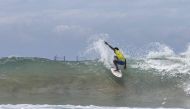 A surfer rides a wave at a surfing competition held at the Tarkwa Bay beach in Lagos Nigeria on 21 May, 2023. (Photo by Benson Ibeabuchi / AFP)