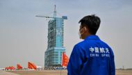 A staff member from the China space program stands before the launch platform of the Shenzhou-16 Manned Space Flight Mission one day before launch at the Jiuquan Satellite Launch Centre in China's northwestern Gansu province on May 29, 2023. Photo by Hector RETAMAL / AFP