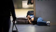 A travelers lies on the ground as he waits for a train after the traffic was stopped at Central rail station in Amsterdam on June 5, 2023. Photo by Koen LAUREIJ / ANP / AFP