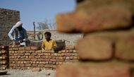 In this photograph taken on May 9, 2023, flood-affected victims rebuild their house in Dadu district of Pakistan. Photo by Rizwan TABASSUM / AFP