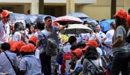 A school staff member instruct students as they evacuate a building in Manila on June 15, 2023, following a magnitude 6.2 earthquake struck the Philippines. (Photo by JAM STA ROSA / AFP)