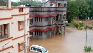 Residents watch as a car drowns in an inundated street at the coastal town of Mandvi as cyclone Biparjoy makes landfall on June 16, 2023. (Photo by AFP)