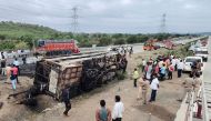 A policeman inspects the wreckage of a bus that caught fire along the Samruddhi Expressway near Sindkhed Raja in Buldhana district of Maharashtra state on July 1, 2023.  (Photo by Gajanan Mehetre / AFP)