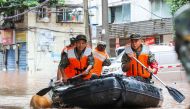 (FILES) This file photo taken on July 4, 2023 shows paramilitary policemen searching an area after it was flooded by heavy rain in China's southwestern Chongqing. (Photo by AFP) / China OUT