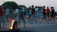 Tunisian youths block the road to migrants by setting tyres on fire as tensions rose in Sfax after the burial of a young Tunisian stabbed to death during a scuffle between residents and migrants from sub-Saharan Africa, on July 4, 2023. (Photo by HOUSSEM ZOUARI / AFP)
