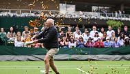 A Just Stop Oil demonstrator throws orange confetti on court 18 as he disrupts the women's singles tennis match between Australia's Daria Saville and Britain's Katie Boulter on the third day of the 2023 Wimbledon Championships at The All England Tennis Club in Wimbledon, southwest London, on July 5, 2023. (Photo by Glyn KIRK / AFP)
