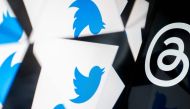 This photo illustration created in Washington, DC, on July 5, 2023, shows the Twitter logo reflected near the logo for Threads, an Instagram app. Facebook owner Meta's new Threads app, meant to compete with Twitter, was available for pre-order on mobile app stores on iPhone and Android operating systems on July 5, 2023. (Photo by Stefani Reynolds / AFP)