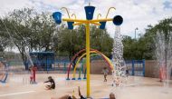 Residents frolic in the splash pad at Brandi Fenton Memorial Park during a heat wave in Tucson, Arizona, on July 15, 2023.  Photo by Rebecca NOBLE / AFP
