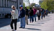 A file photo of people lining up outside a career center for in-person appointments in Louisville, US.