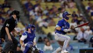 Daulton Varsho #25 of the Toronto Blue Jays watches his two run double with Will Smith #16 of the Los Angeles Dodgers and umpire Chris Segal, to take a 5-3 lead, during the 11th inning at Dodger Stadium on July 24, 2023 in Los Angeles, California. (Photo by Harry How / GETTY IMAGES NORTH AMERICA / Getty Images via AFP)
