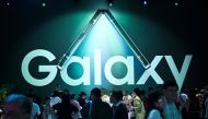 Attendees walk past the logo of Samsung Galaxy during the Samsung Galaxy Unpacked 2023 event in Seoul on July 26, 2023. (Photo by Jung Yeon-je / AFP)